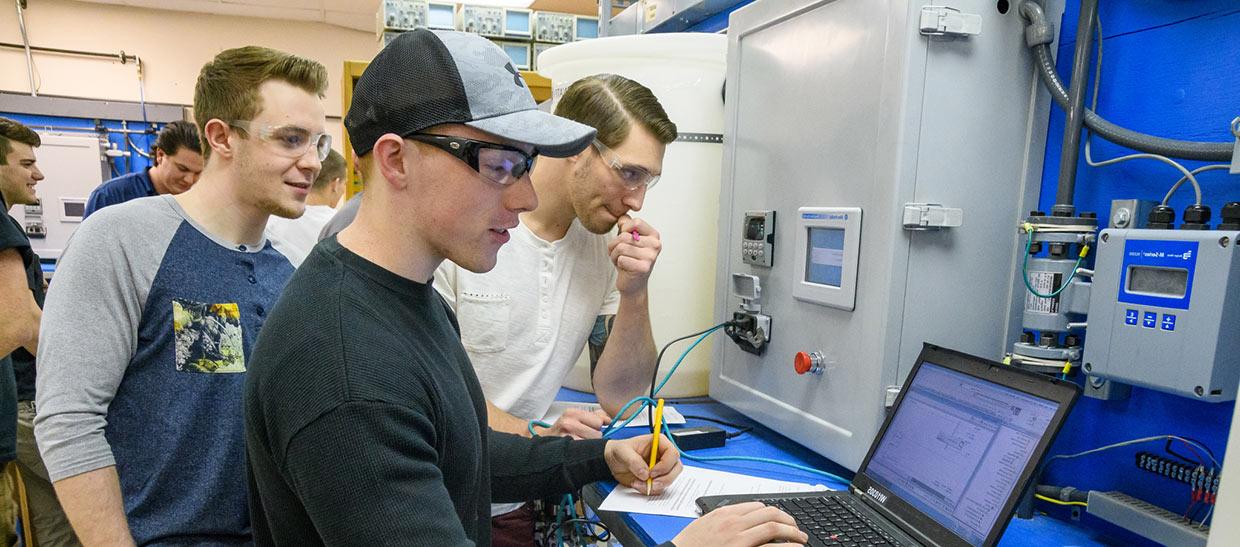 Mechatronics students working on a computer