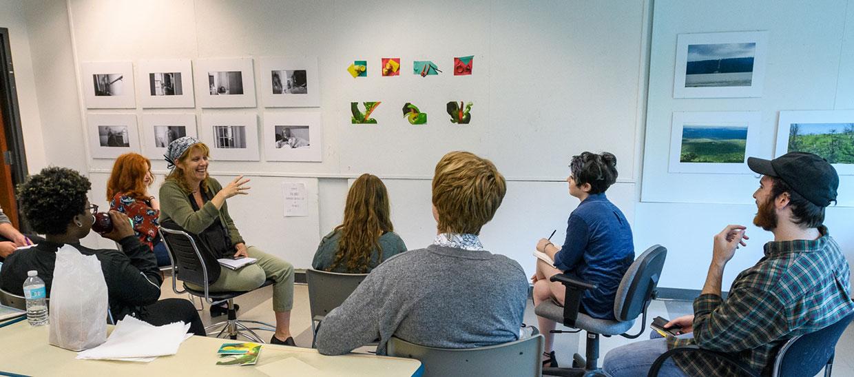 学生s looking at artwork in a classroom with instructor