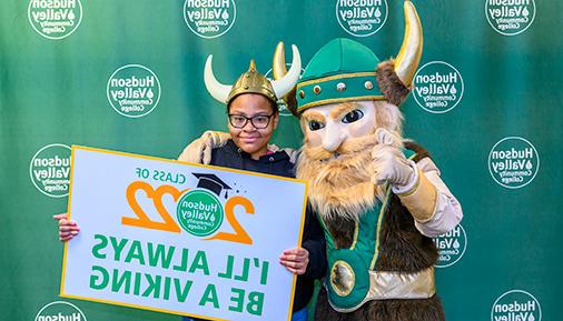 Graduate poses with Viking mascot and class of 2022 sign